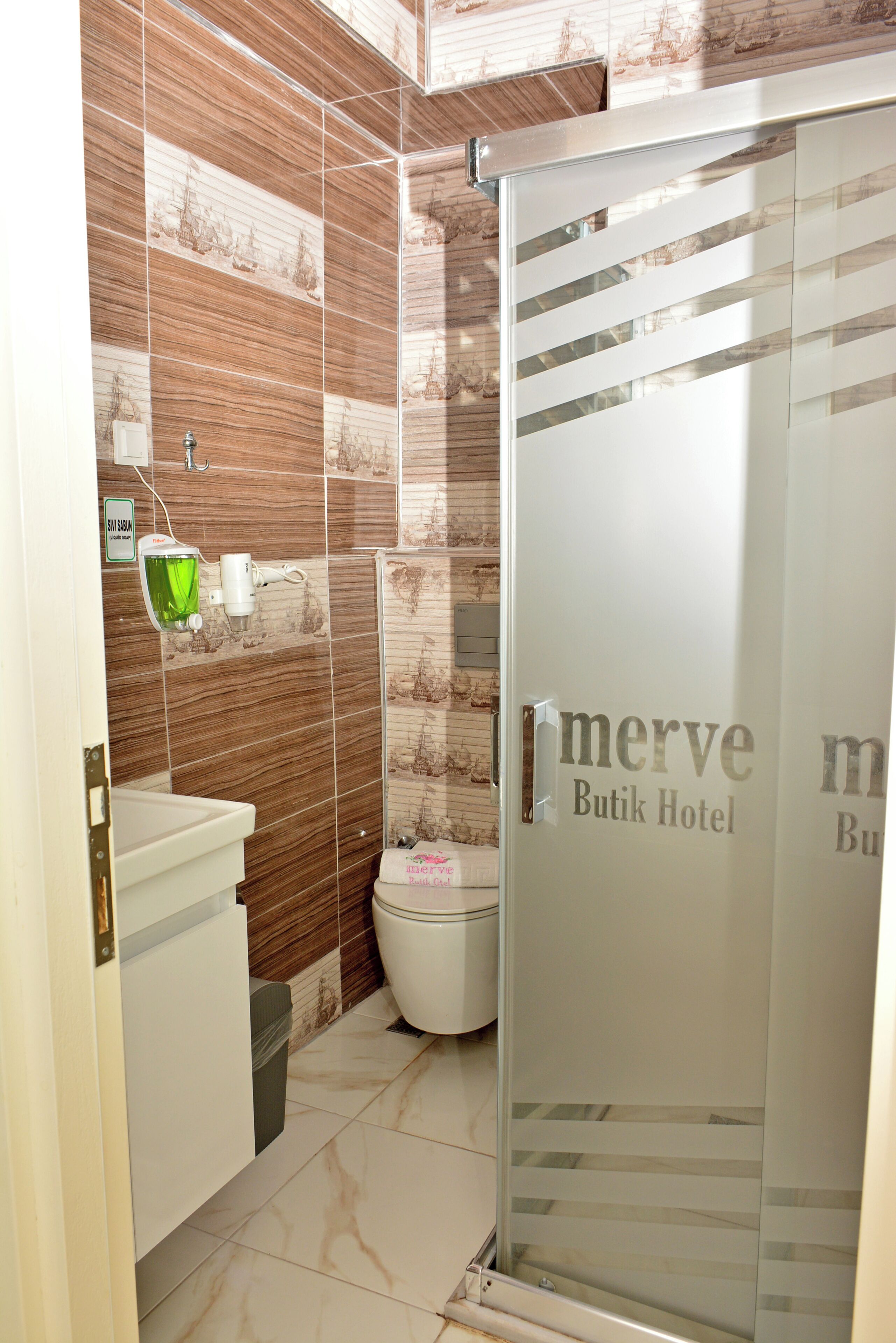 A bathroom with a glass shower enclosure, a sink, and a toilet.