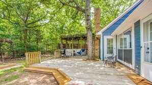 A wooden deck with a grill, outdoor seating, and a covered area. - Stunning Lake House 4Bdm w/ Sandy Beach Access (Pottsboro)