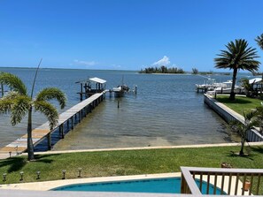A waterfront property with a dock, a swimming pool, and a view of the water. - Waterfront Studio with pool and boat dock (Sebastian)