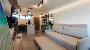 A modern living room with a sofa, a coffee table, and a TV mounted on the wall. - Maui Beach Residence (Tamandaré)