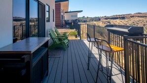 Una terraza con mobiliario exterior y vistas del paisaje circundante.