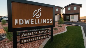 A sign for 'The Dwellings' with a logo, indicating it's a vacation rental property. - Incredible View #5 at The Dwellings (La Verkin)