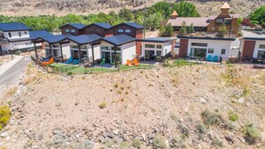 Un edificio moderno con varias unidades, un espacio exterior cubierto y un paisaje montañoso al fondo.
