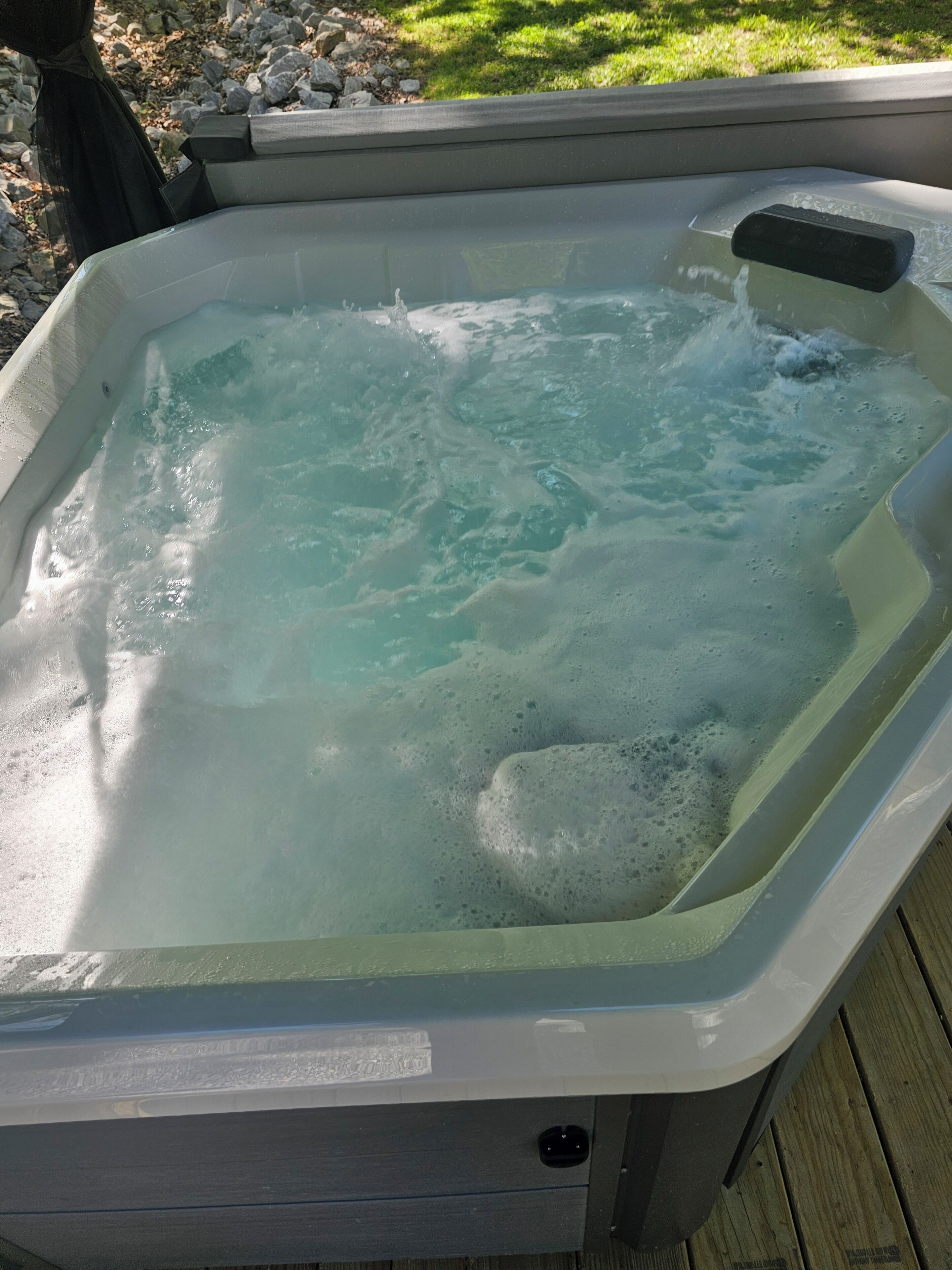 Ett bubbelbad med vatten, en pump och en träplattform.