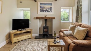 Una sala de estar acogedora con televisión, muebles de madera, chimenea y sofá.