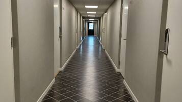En lång, smal hall med ett klinkergolv och ett takfönster i änden.