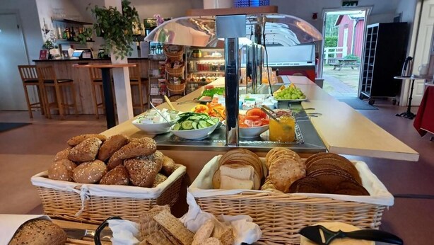 A buffet with various breads, cheeses, and fruits. - Hotell Solstickan Mellbystrand (Mellbystrand)