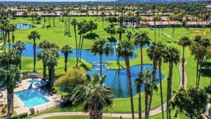 Un parcours de golf comportant de nombreux obstacles d’eau, des palmiers et un espace piscine.