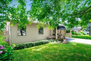 Ein Wohnhaus mit Veranda, kleinem Garten und blauem Himmel.