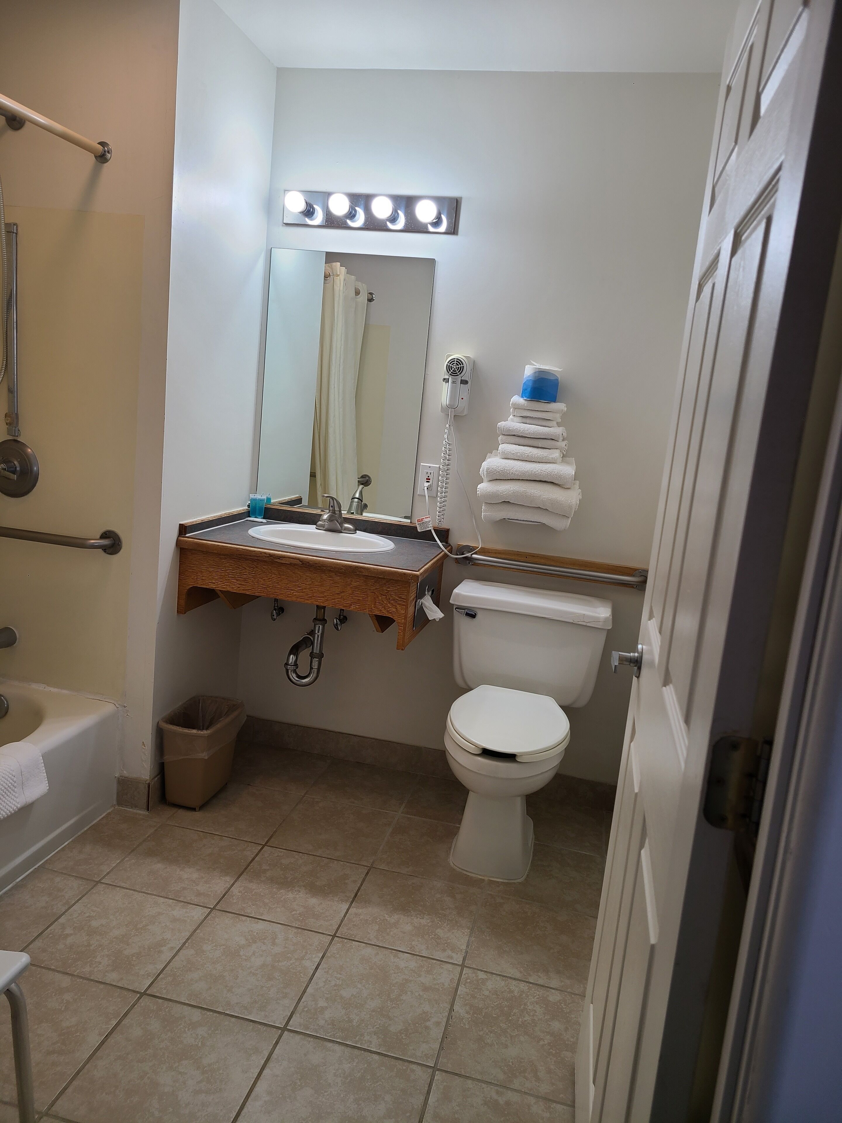 Ein Badezimmer mit Waschbecken, Spiegel, Toilette und Duschbereich.