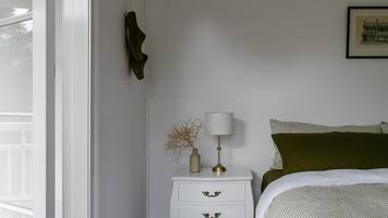 A bedroom with a bed, a nightstand, a lamp, and a framed picture on the wall.