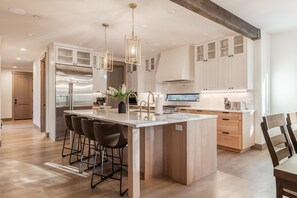 A modern kitchen with a central island, stainless steel appliances, and wooden cabinetry. - Family Friendly w/ Suncadia Pool Access (Cle Elum)