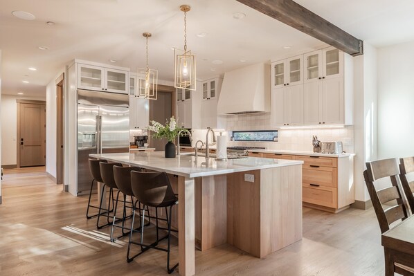A modern kitchen with a central island, stainless steel appliances, and wooden cabinetry.