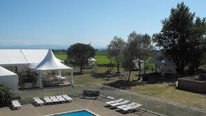 A swimming pool with lounge chairs and a white tent structure. - Domaine de Garabaud (Mazeres)