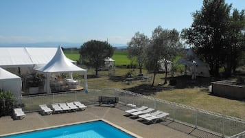 Una piscina al aire libre de temporada, sillones reclinables de piscina