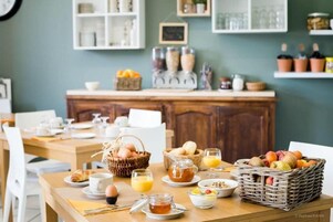Un desayuno con una mesa de madera, cestas de frutas, huevos y una estación de café.