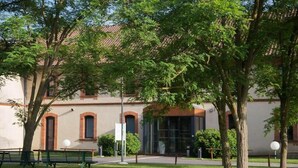 A building with a traditional architectural style, featuring arched windows and a brick facade. - Domaine de Garabaud (Mazeres)