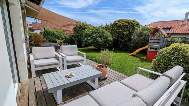 An outdoor deck with a white sofa set, a table, and a potted plant. - Quiet house + T2, garden & Spa, close to beaches (Anglet)
