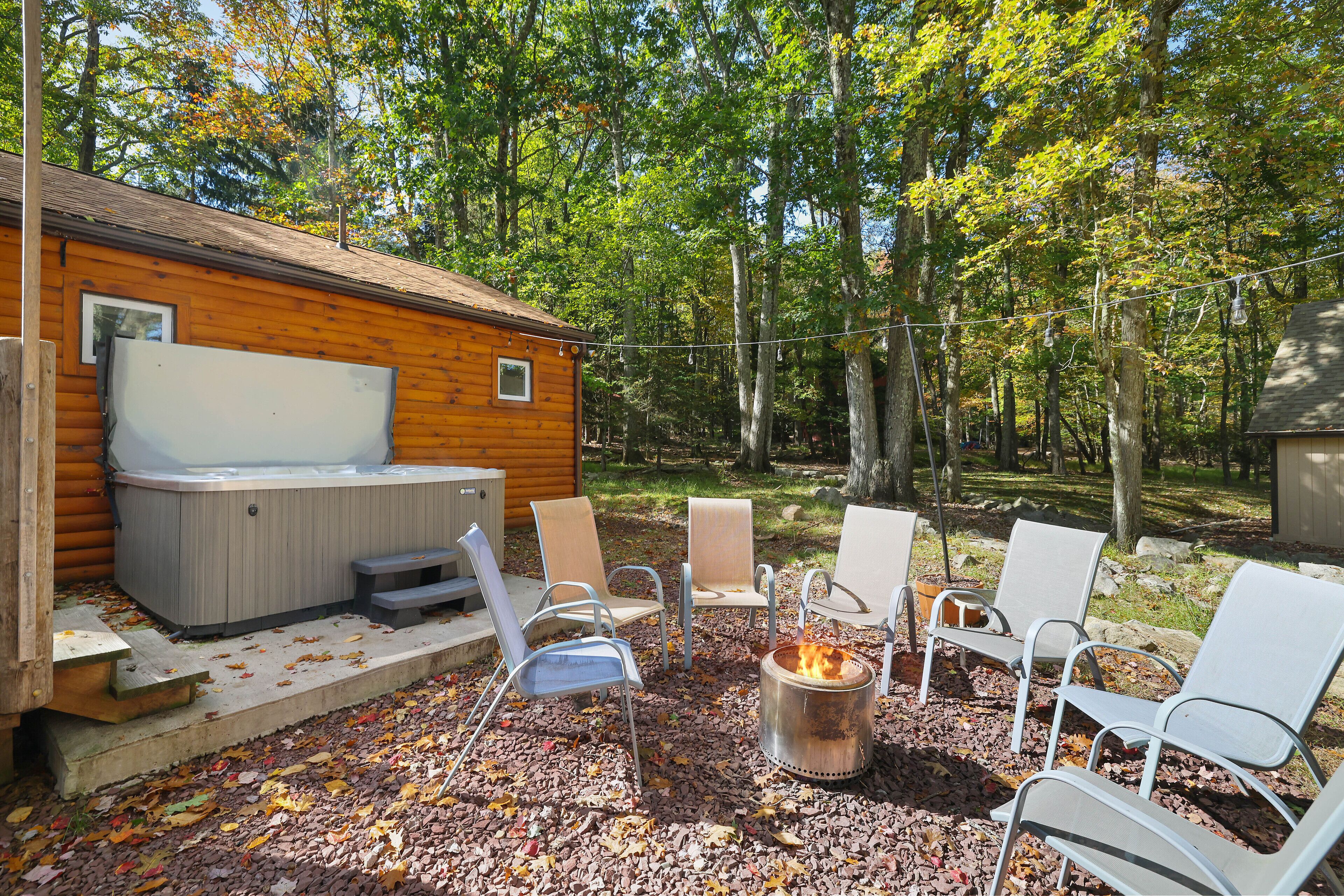 A wooden cabin with a hot tub and outdoor seating.