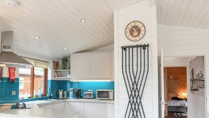 Una cocina moderna con armarios blancos, una isla central y un salpicadero azul.