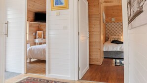 Una habitación con una cama, una mesita con una lámpara y un cuadro en la pared.