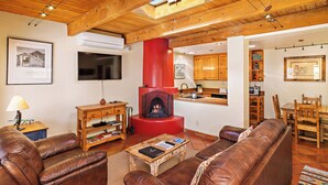 Ein gemütliches Wohnzimmer mit Kamin, Ledersofas, Holzmöbeln und einem Fernseher.