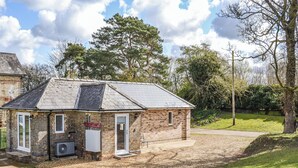Ein kleines Backsteinhaus mit geneigtem Dach, einer Tür und einer Klimaanlage.