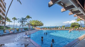 A swimming pool with lounge chairs and palm trees, overlooking a beach and ocean. - UPGRADED-Sands of Kahana #275 OCEANFRONT, 3 Bed Rooms, sleeps 10 - Central AC (Lahaina)