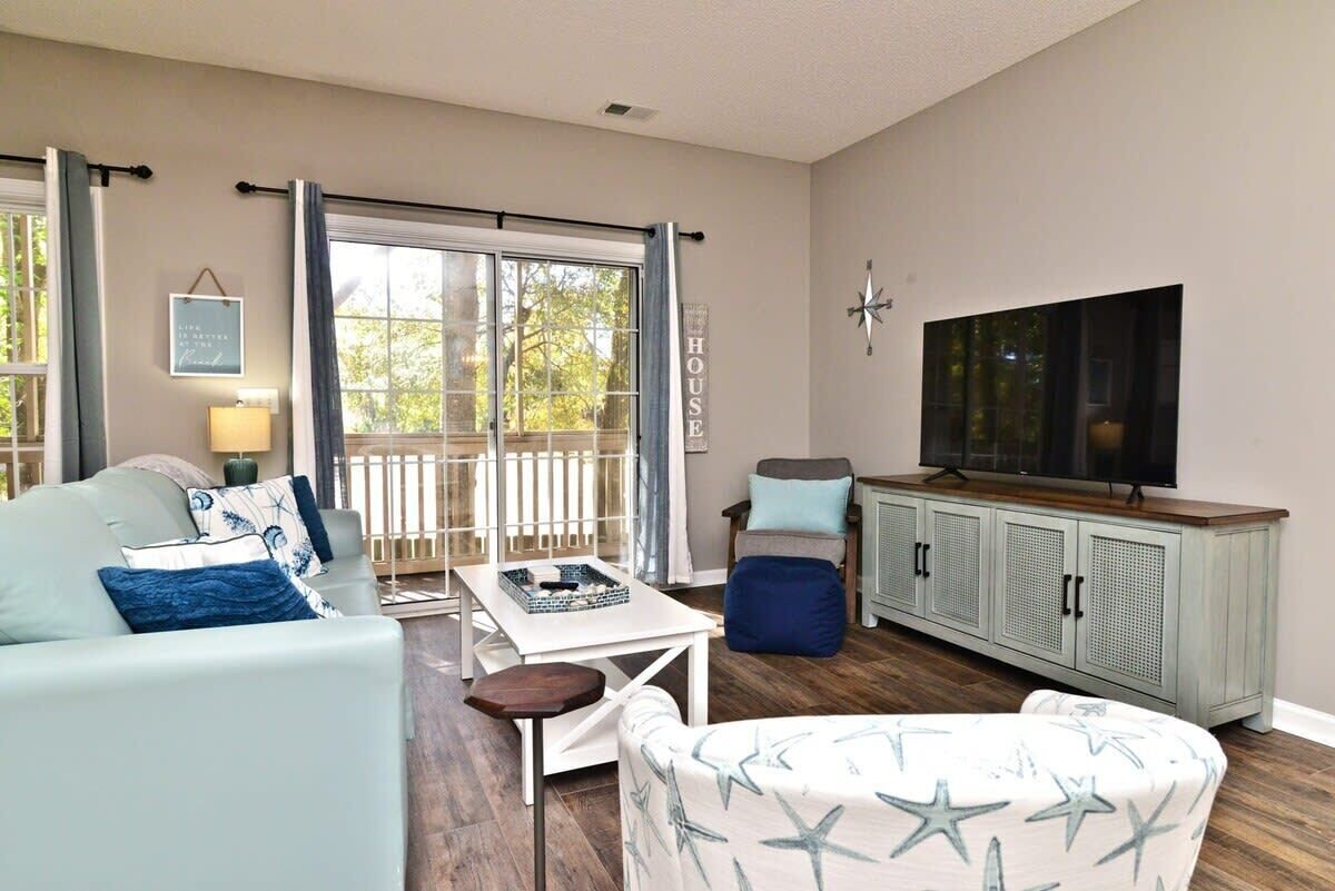 A living room with a sofa, a small table, a cabinet, and a television.