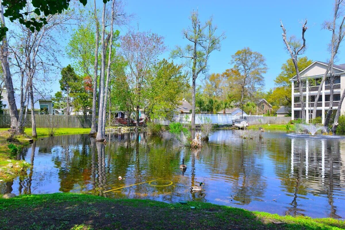 Ein Wohngebiet mit Teich, Häusern und einem Mehrfamilienhaus.