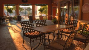 An outdoor patio with a table and chairs, potted plants, and a view of the cityscape. - 2BD/Orlando near Disney - Park Shuttle, Pools, Game Room, and more! (Lake Buena Vista)