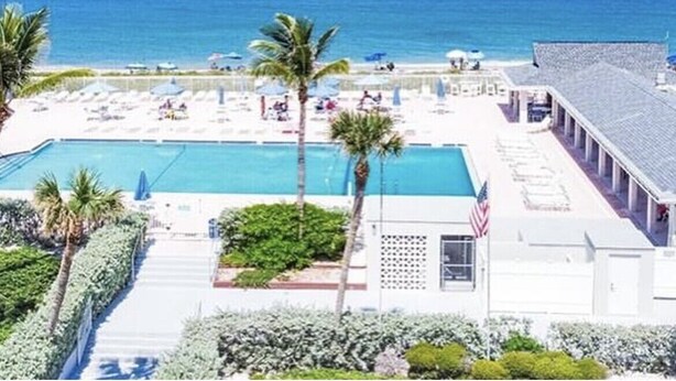 Un resort con piscina, playa y vista al océano.