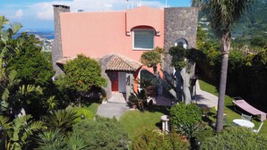 A house with a stone facade, a red door, and a small patio area with a bench and a hammock. - Villa Stefania - Entire Villa (Barano D'ischia)