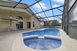 Ein Schwimmbad mit Glasdach, Liegestühlen und einer Terrassenanlage.