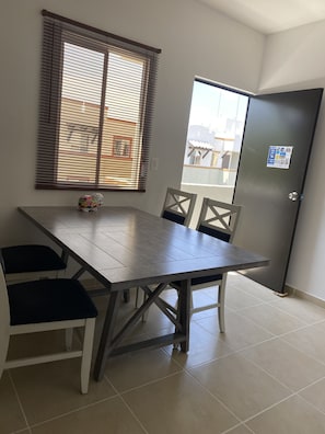 Enjoy meals together at the dining table, accompanied by comfortable seating for four.