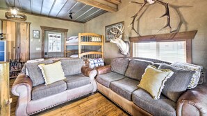 A cozy living room with leather sofas, a wooden ceiling, and antler decorations. - Renovated Bunkhouse on 12-Acre Horse Farm! (Perrysville)