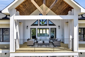 Relax in a covered outdoor seating area with a beautiful view.