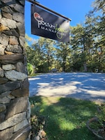 Un edificio de piedra con un letrero que dice 'Possum Lodge Manapouri'.