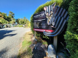 A sign for Possum Lodge Manapouri with a list of amenities including motels, cabins, and backpackers, all marked as vacant.