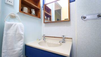 Ein Badezimmer mit Waschbecken, Spiegel und Handtuchhalter.