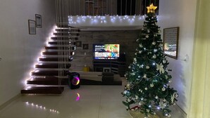 A staircase with LED lights, a Christmas tree, and a flat-screen TV in a living room. - Two-story house with pool, well located, 5 minutes from Flamboyant Shopping Center. (Goiânia)