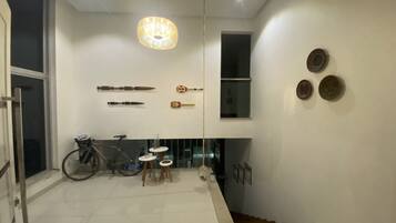 A modern interior with a staircase, a bicycle, and wall-mounted artifacts.