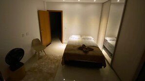 A bedroom with a bed, a chair, a desk, and a wardrobe. - Two-story house with pool, well located, 5 minutes from Flamboyant Shopping Center. (Goiânia)