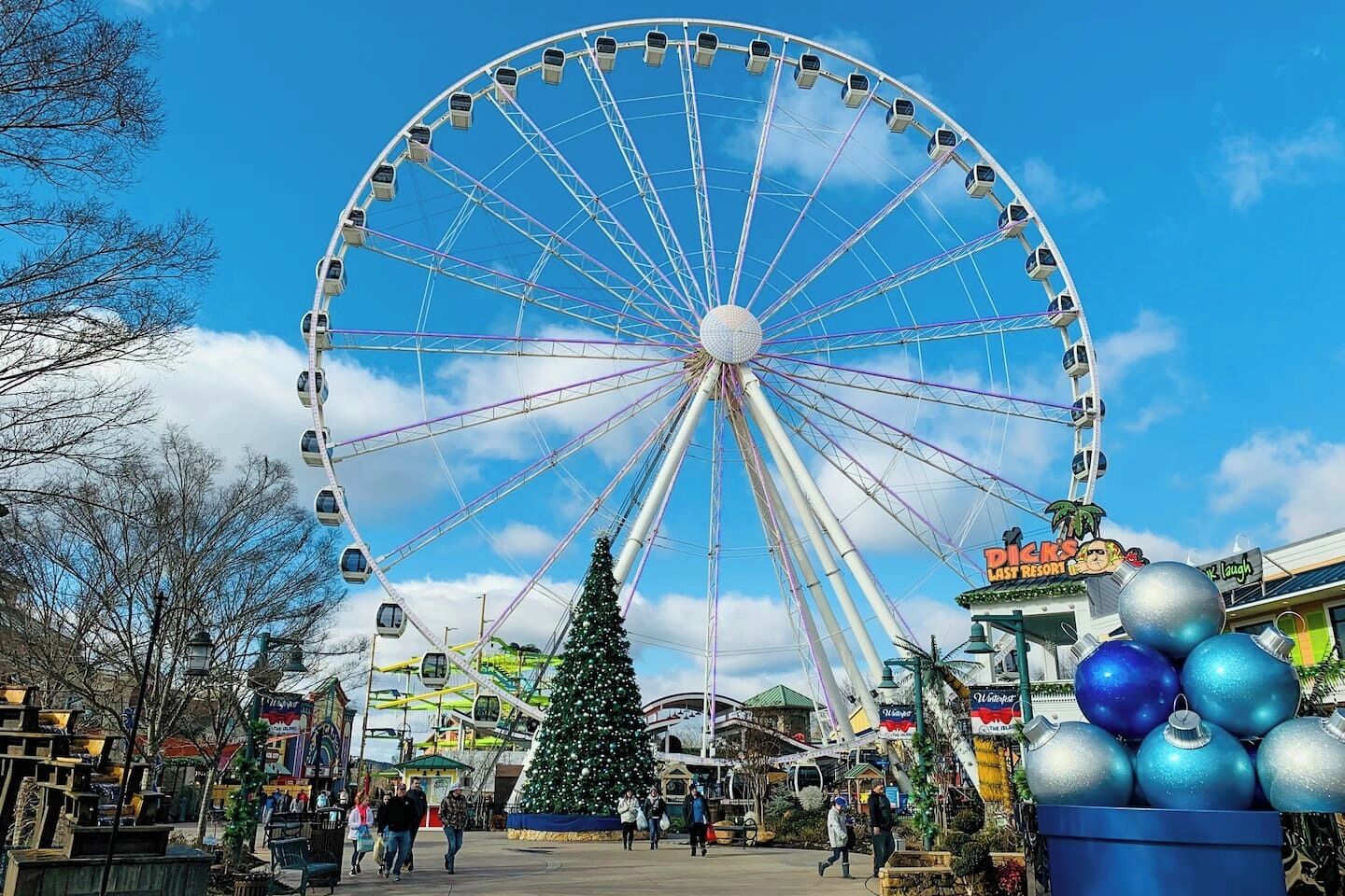 A large Ferris wheel, a Christmas tree, and a sign for 'Dicks Last Resort.'