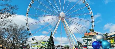 A large Ferris wheel, a Christmas tree, and a sign for 'Dicks Last Resort.'