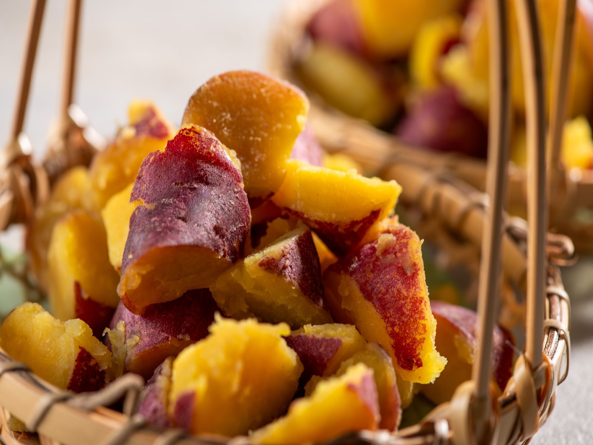 A basket filled with sliced fruits, likely peaches or nectarines, with a wicker handle.