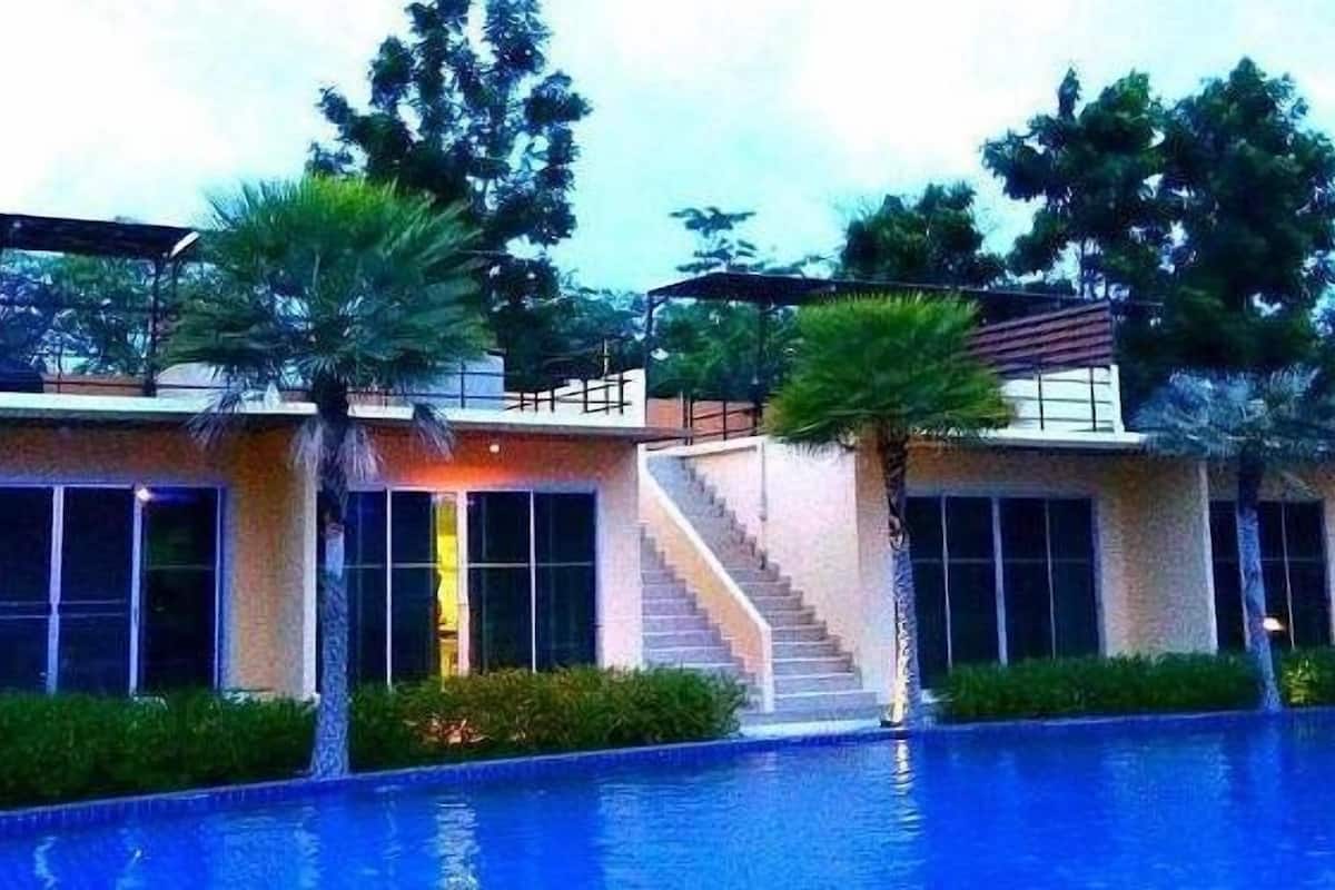 A modern hotel with a swimming pool, a staircase, and a covered outdoor area.