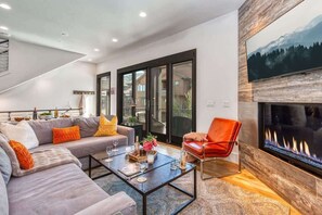 Una sala de estar moderna con un sofá, una mesa de centro y una chimenea.