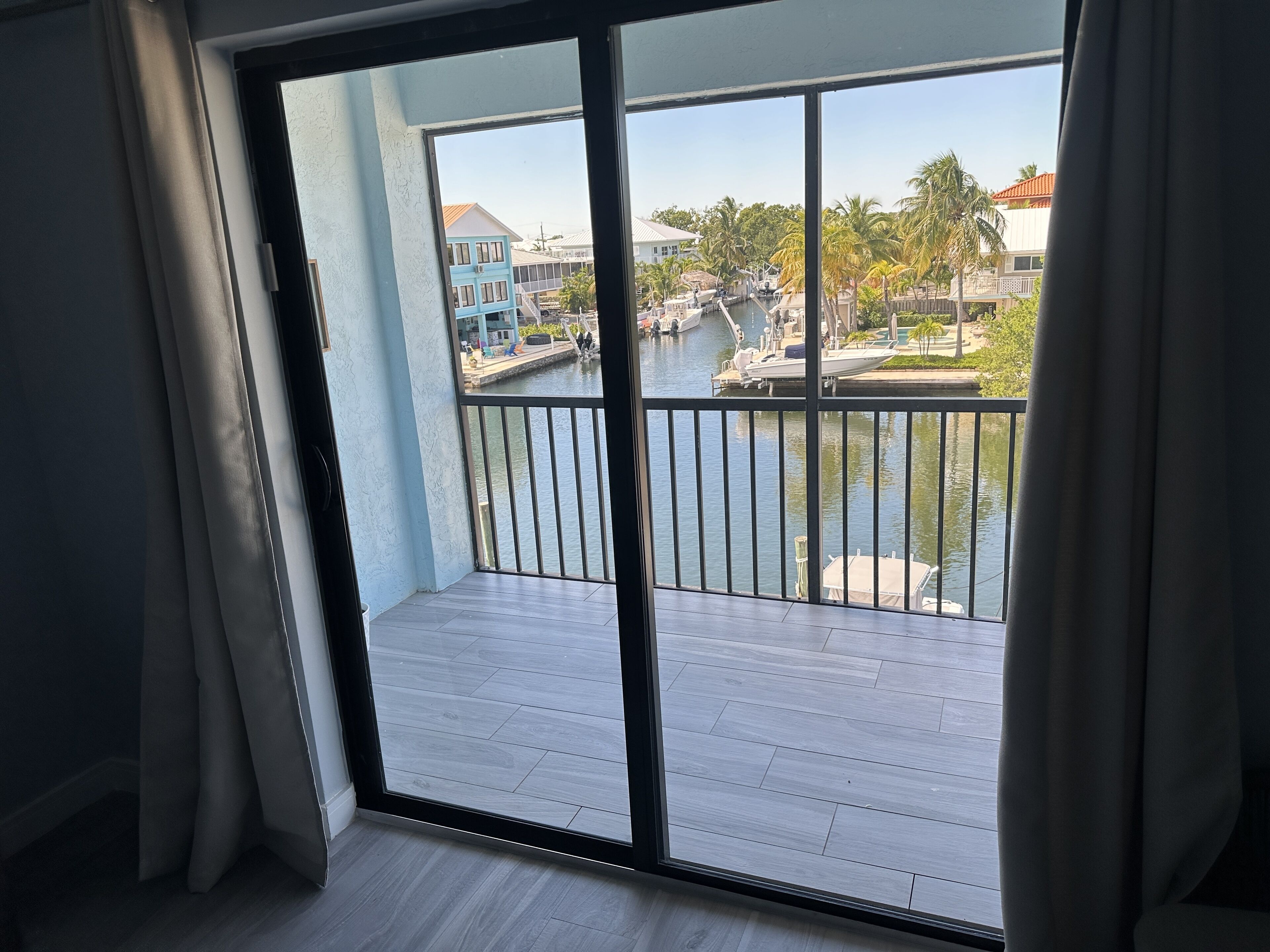 A balcony with a view of a marina, including boats and buildings.