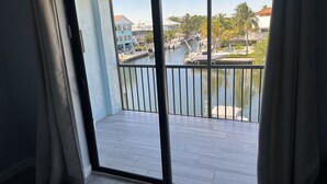 A balcony with a view of a marina, including boats and buildings. - Re-energize at our spacious condo! Enjoy 10% off stays of 7+ days. Book now! (Key Largo)